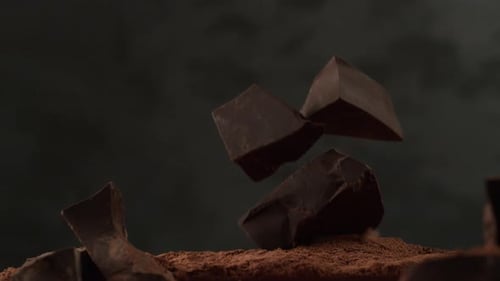 Chocolate Chunks Falling Into Cocoa Powder In Slow Motion. Shot With Phantom Flex 4k Camera.