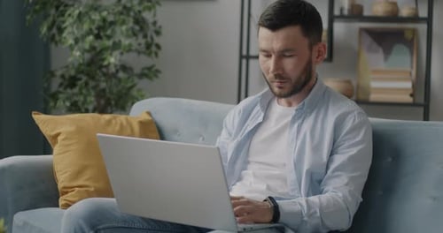 Man Working on Laptop Computer at Home