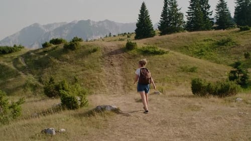 Woman Hikes Mountain Trail on Sunny Day