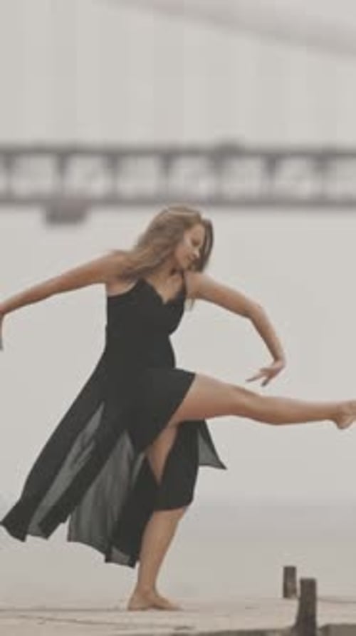 Graceful Young Woman Dancing on Pier Near the Water