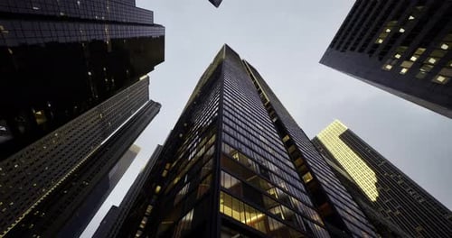 Vista hacia el cielo de un rascacielos moderno en medio de la arquitectura urbana en el crepúsculo