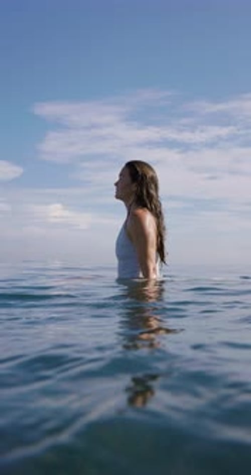 Surfer Woman Sitting on Surfboard and Waiting Wave in Ocean