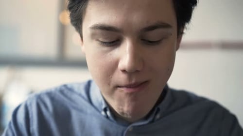 Teenager Eating Hamburger Sandwich In Fast Food Bar
