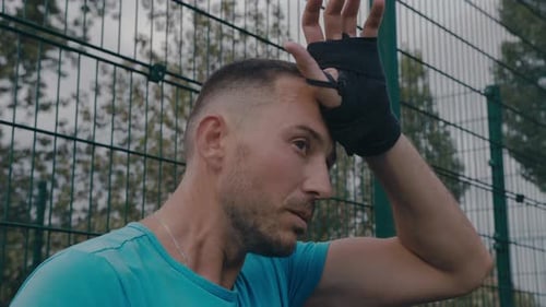 Athletic Man Wipes Sweat After Workout