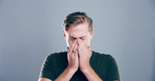 4k-Videomaterial eines jungen Mannes, der vor grauem Hintergrund weint