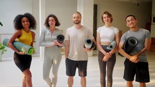 Diverse Men and Women Posing at Yoga Studio with Mats