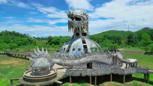 A Striking Aerial View of a Dragon Statue at an Abandoned Waterpark Surrounded By Lush Greenery