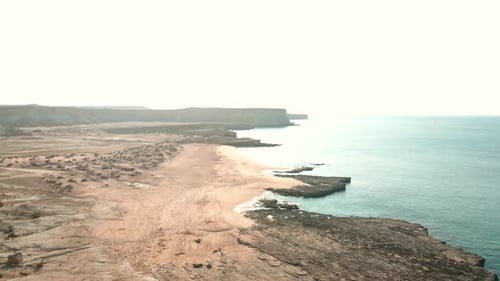 4K Aerial View of a Remote Coastal Landscape with Rocky Shores