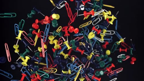 Colorful Paper Clips and Push Pins on Black Surface