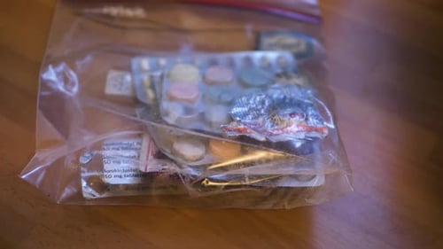 Throw bag of old medicines on the table for disposal. Close-up, real time