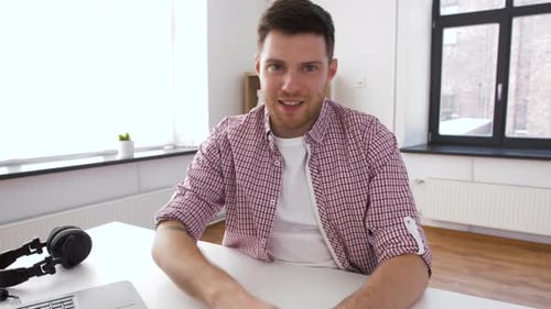 Man Talking and Gesturing at Desk Indoors