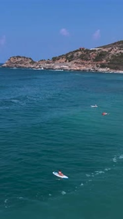 Vertical Video Mediterranean SUP Festival Features People Paddleboarding By Stunning Cliffs and