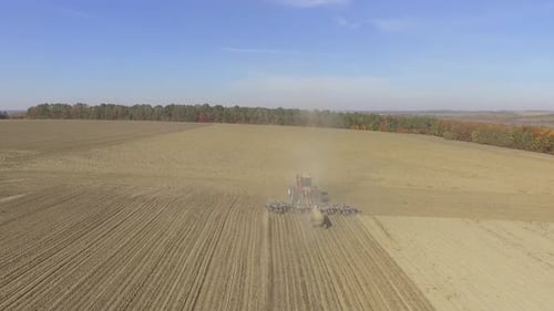 Big red tractor working on the field cultivating and applying nitrogen ASP