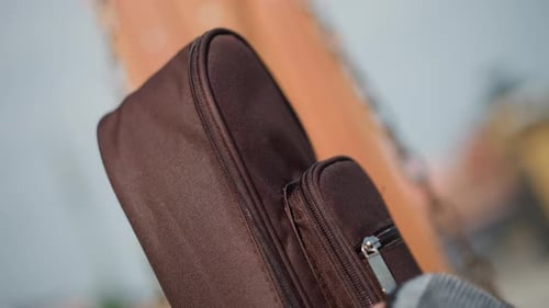 Waiting for Performance to Start Musician Prepares Instrument Under City Dusk Detail of Leather