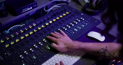 Over Shoulder Shot Sound Producer Hand is Using a Music Mixer with Editing Tools in Recording Studio