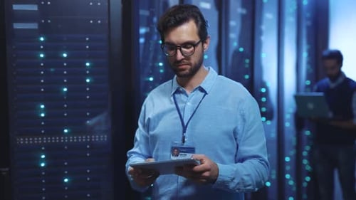 Data center worker using tablet for server maintenance