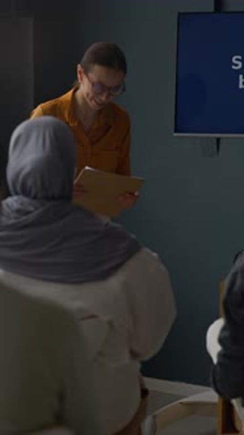 Woman Giving Presentation to Small Group in Office