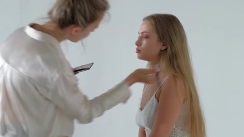 Makeup Artist Applying Makeup to Model in Studio