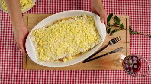 Preparing Lasagna: Cheese Topped Dish on Cutting Board