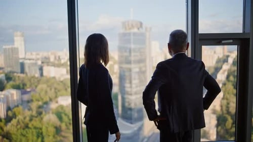 Confident Partners Shaking Hands Standing By Panoramic Office Window Together