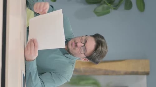 Man Holding Papers Indoors