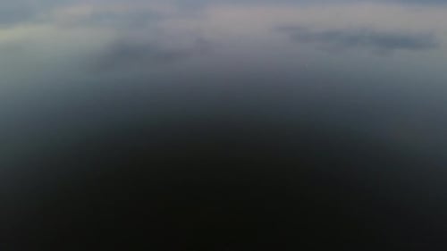 Luftaufnahme mit Blick auf See und Berge mit Himmelsreflexion.