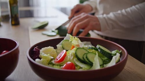 Salad Preparation: Close-up of Hands Cutting Cucumbers