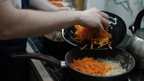 Adding Shredded Carrots to Onions in Frying Pan