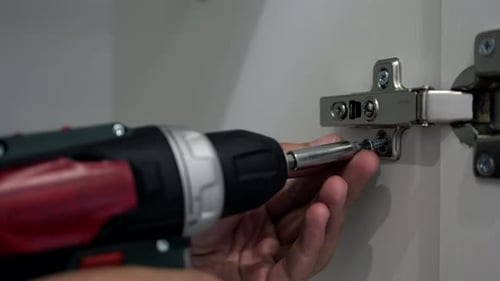 Close Up of Power Drill Repairing Cabinet