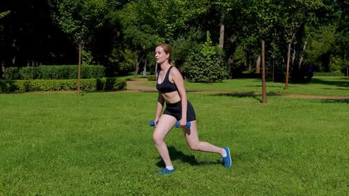 Motivated Active Sporty Fitness Woman Practicing Dumbbell Reverse Lunges in Park