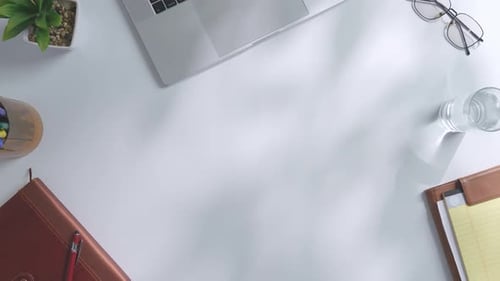 Top down view of a mock up green screen laptop computer on a white office desk