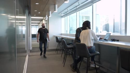 Office Work: Man Walking By Colleagues Using Laptop