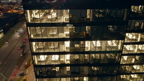 Drone Eye View of LateNight Corporate Work in a Glass Skyscraper