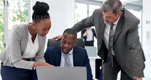 Business Colleagues Collaborate on a Laptop in Office