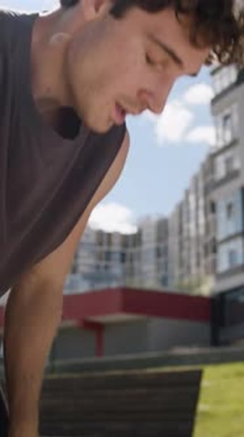 Un sportif caucasien termine une course complète en ville, respirant, sensation de fatigue, étouffement