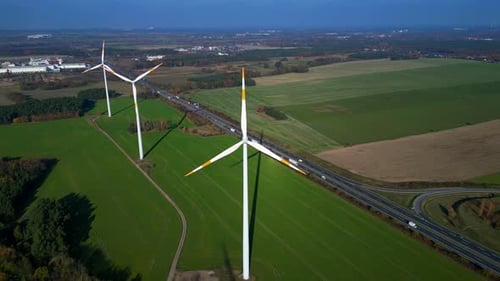 Wind farm Windmill turbines near highway clean energy. Perfect aerial view flight drone