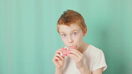 Un niño muerde una rosquilla y hace ojos de sorpresa