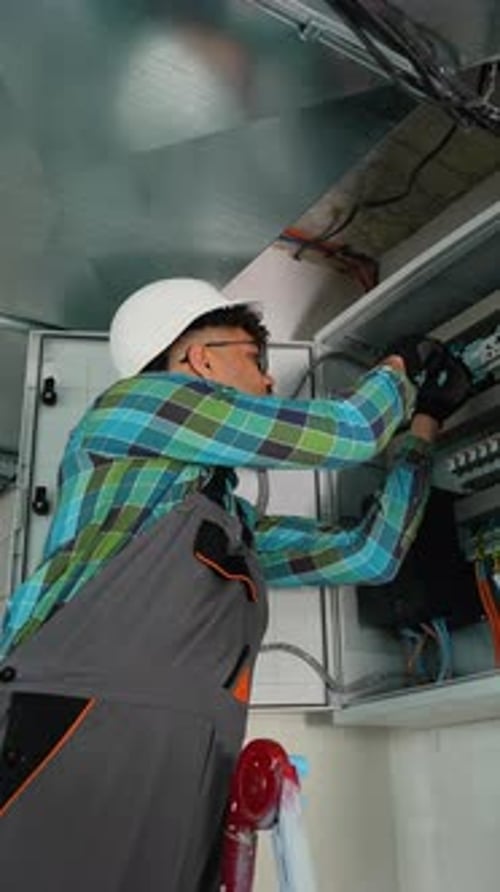 Electrician Working on Electrical Panel Installing New Components