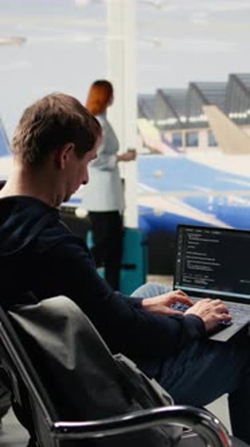 Vertical Video Digital Nomad Man Programming on Laptop in International Airport