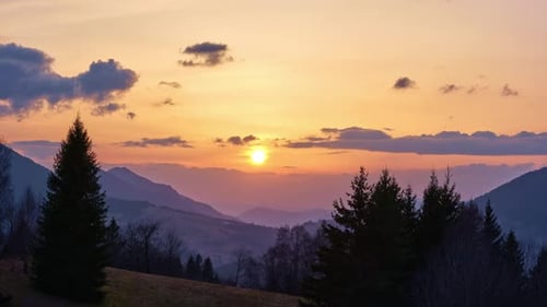 Sunset Over Mountain Range With Evergreen Trees