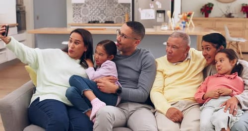 Happy Family Poses for Selfie on Couch