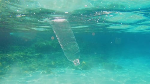 Plastic pollution in sea ocean - big environmental problem. Plastic bag and bottle floating in sea.