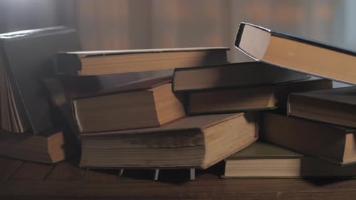 Pile of Aged Books on Wooden Surface