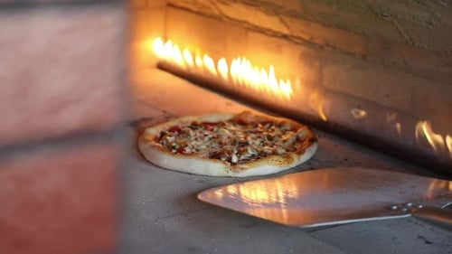 Pizza Cooking Inside of a Fiery Brick Oven