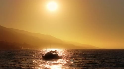 Boat Sailing Along Water at Golden Hour