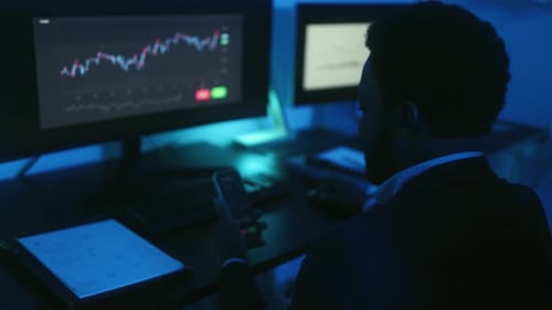 Financial analyst working on stock exchange market while doing a video call in office