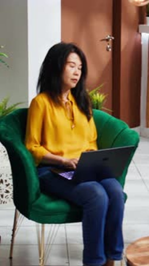 Vertical Video Hotel Guest Working on Laptop in Lounge Area Lobby