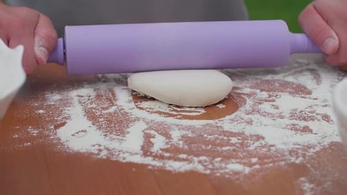 Flattening Dough with Rolling Pin for Baking