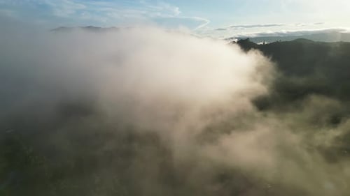 Luftflug über niedrigen Wolken in der morgendlichen Naturlandschaft