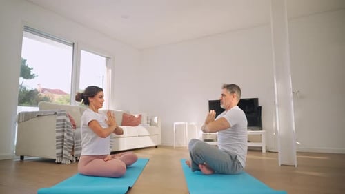 Couple Exercising Together Doing Yoga in Living Room